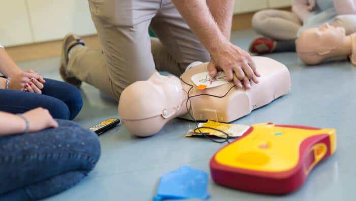 Students learn how to perform CPR and attach an AED to a manikin in Folsom California.